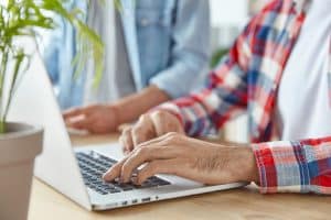 unrecognizable man freelancer his partner keyboards laptop computer work distantly